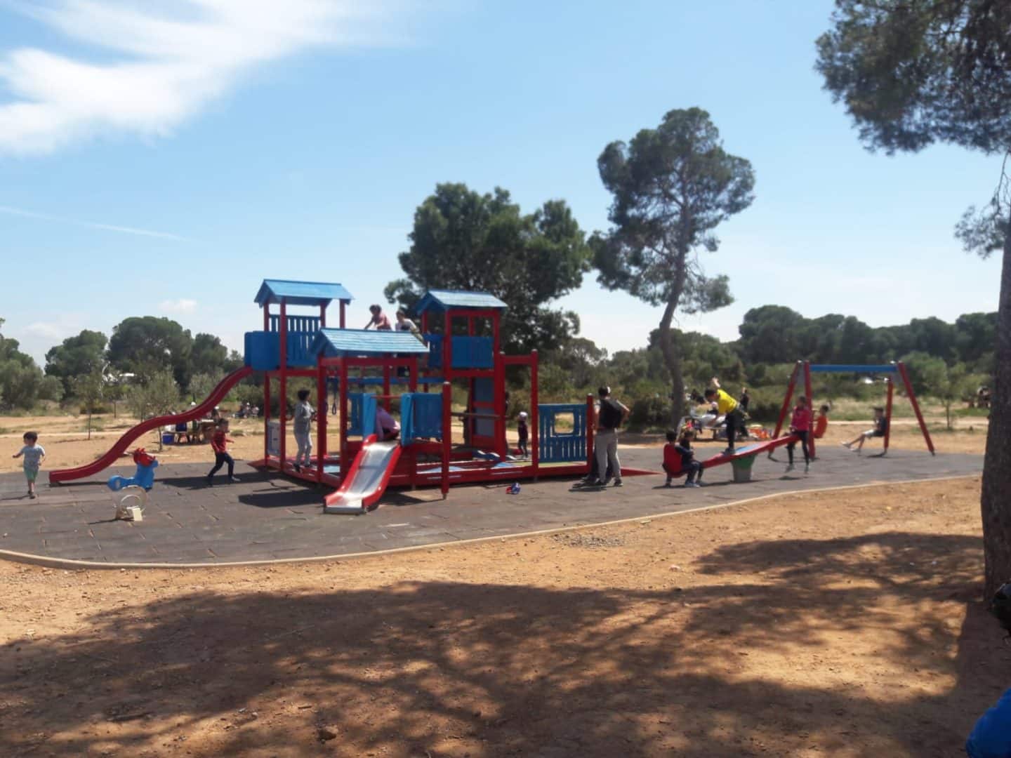 Merendero con mesas bajo los pinos en el área recreativa de Porta Coeli
