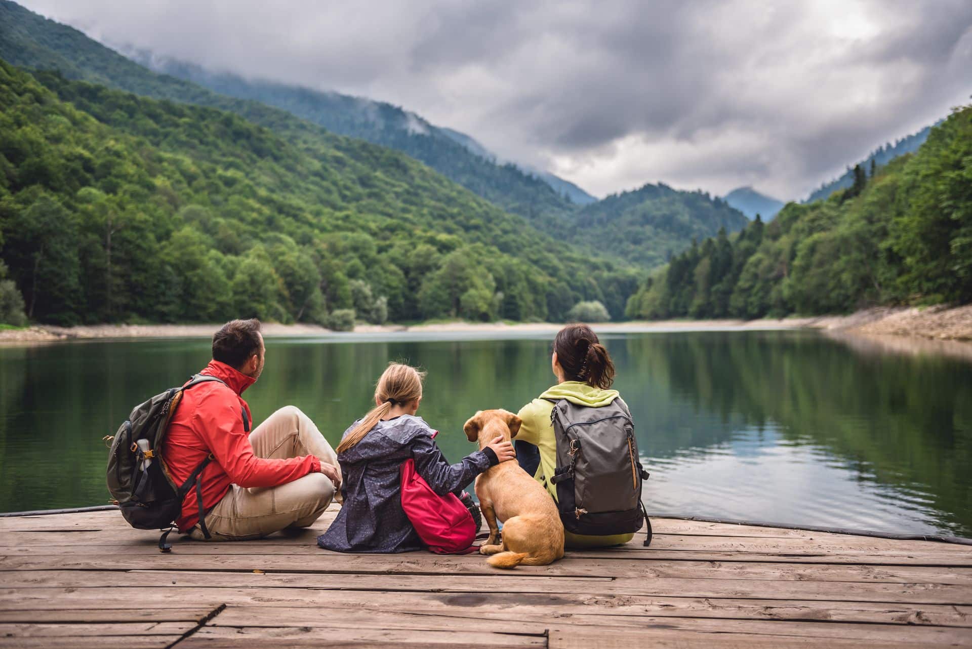 Familia de escapada rural en la montaña con vistas a un lago y vegetación